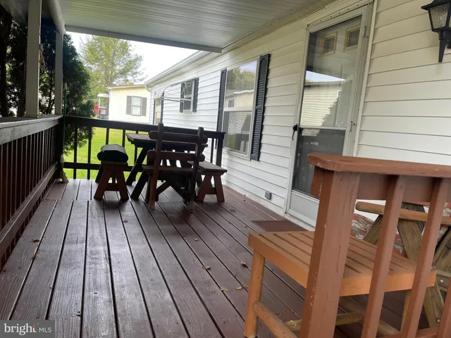 a view of a patio with table and chairs with wooden floor and fence