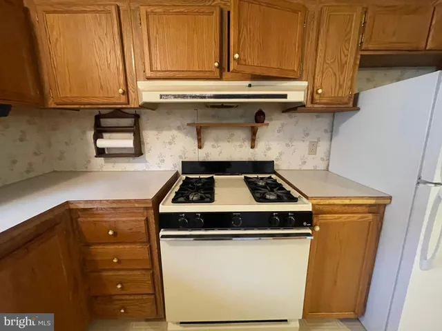 a stove top oven sitting inside of a kitchen