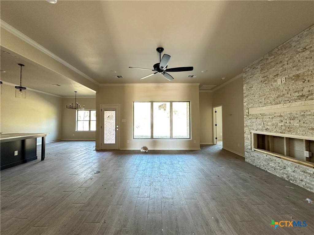 3502 Prato Lane Temple, TX 76502 - Photo 3 of 32 an empty room with wooden floor a fireplace and windows