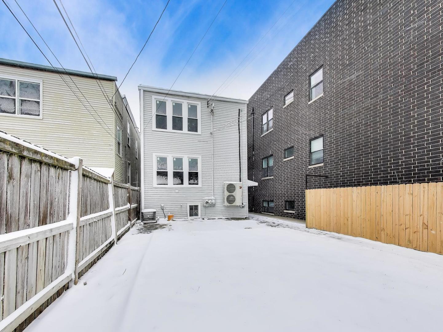 4213 West Roscoe Street, Unit 1 Chicago, IL 60641 - Photo 13 of 15 a view of a house with a wooden fence