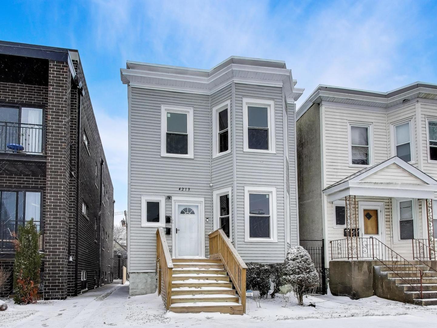 4213 West Roscoe Street, Unit 1 Chicago, IL 60641 - Photo 2 of 15 a front view of a house with a yard