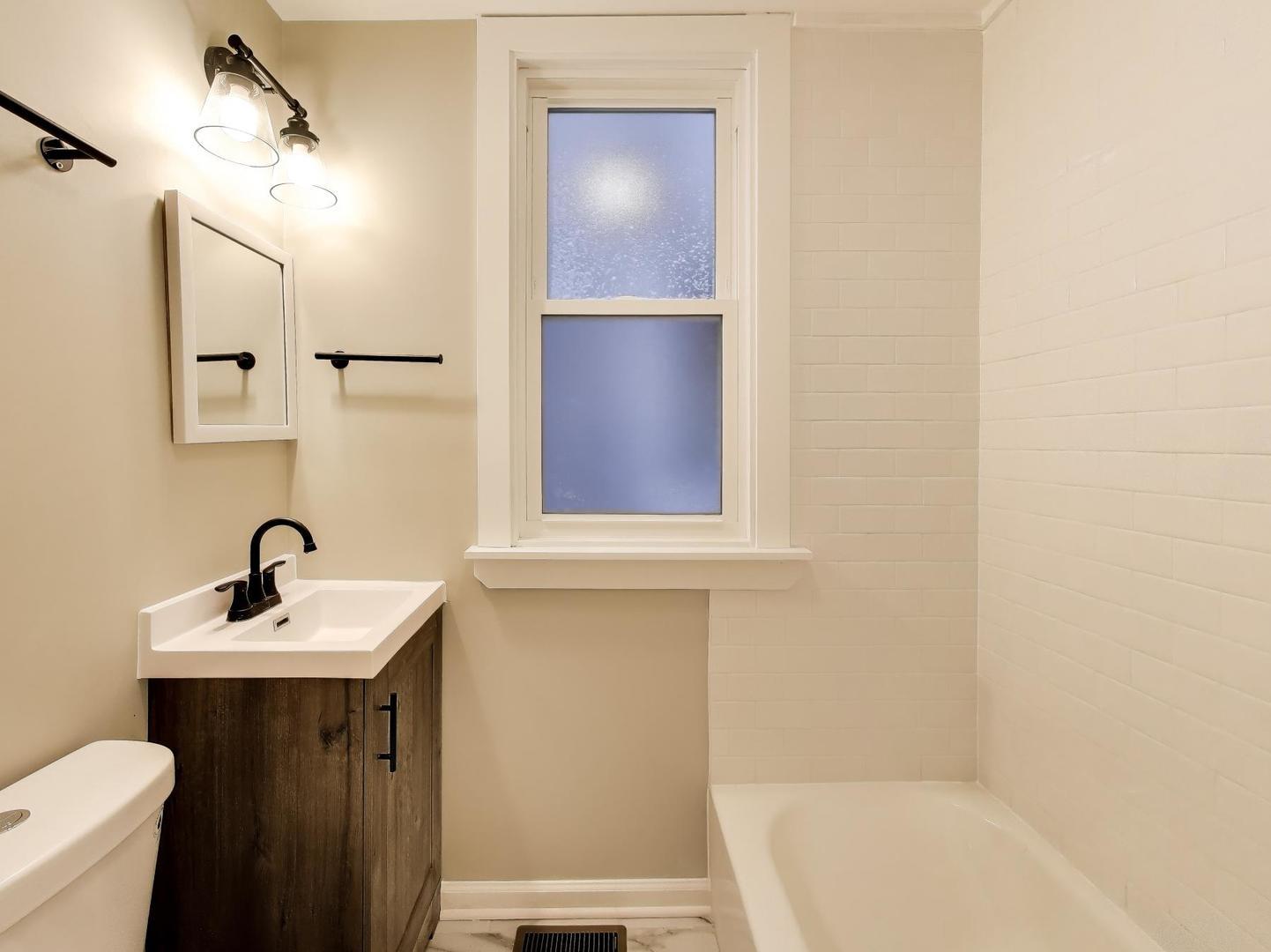 4213 West Roscoe Street, Unit 1 Chicago, IL 60641 - Photo 9 of 15 a bathroom with a sink and a mirror