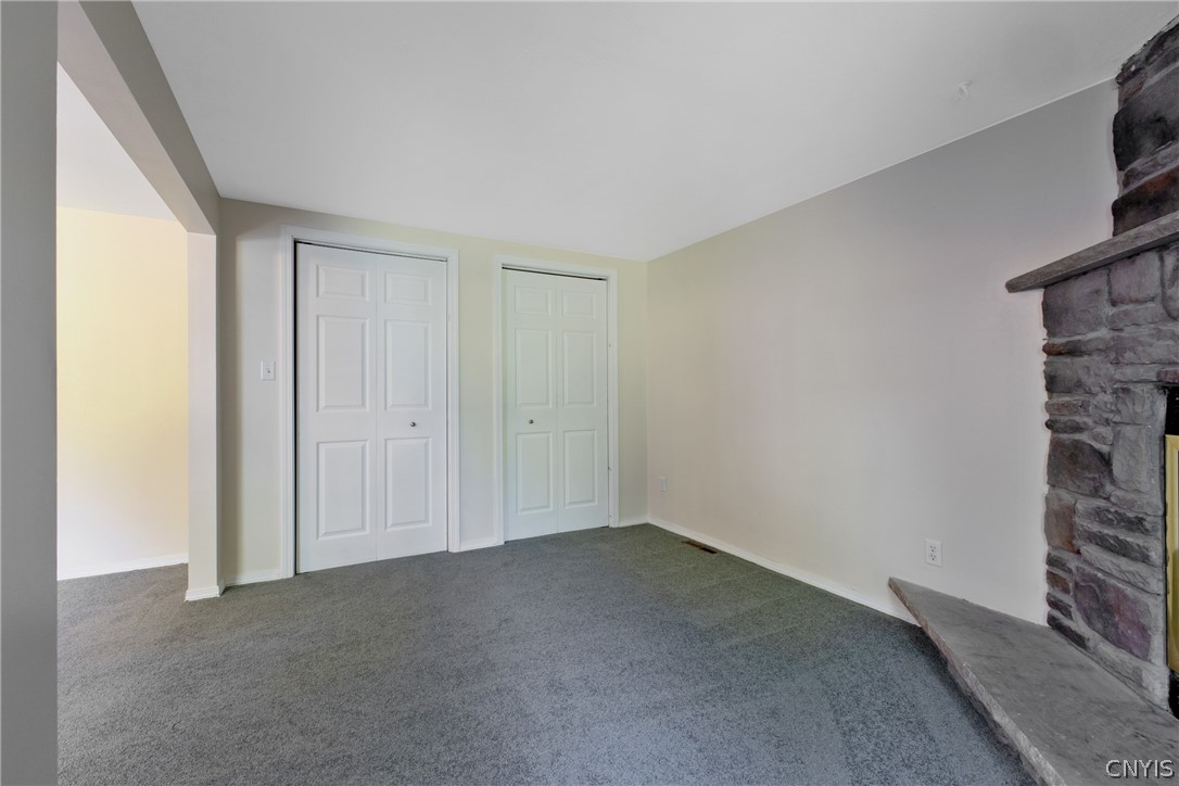 125 Circle Road Salina, NY 13212 - Photo 23 of 39 Primary bedroom with seating area, wood fireplace, double closets, & full bath.