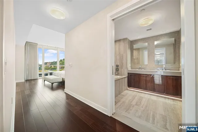 a spacious bathroom with a double vanity sink a mirror and a bathtub