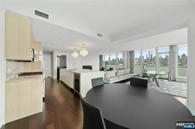 a large living room with stainless steel appliances kitchen island furniture and a large window