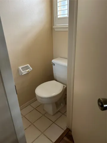 a white toilet sitting next to a window