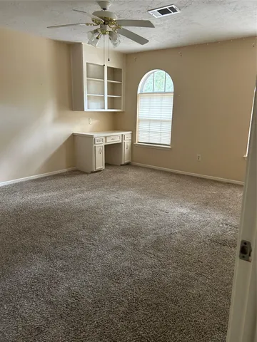 an empty room with a fireplace and windows