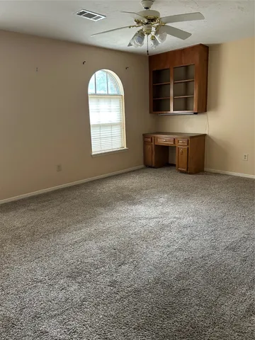 an empty room with a fireplace and windows