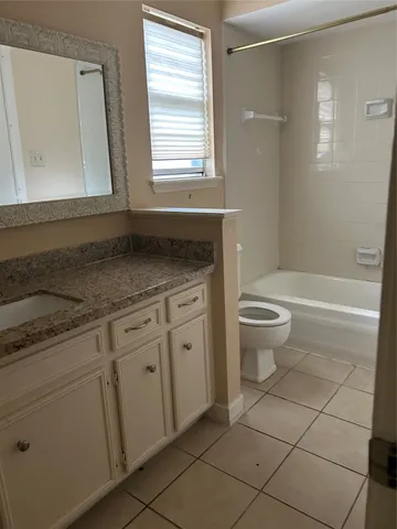 a bathroom with a granite countertop sink a toilet and a mirror