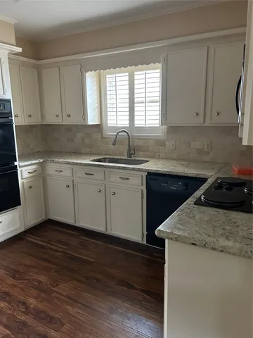 a kitchen with sink a window and cabinets