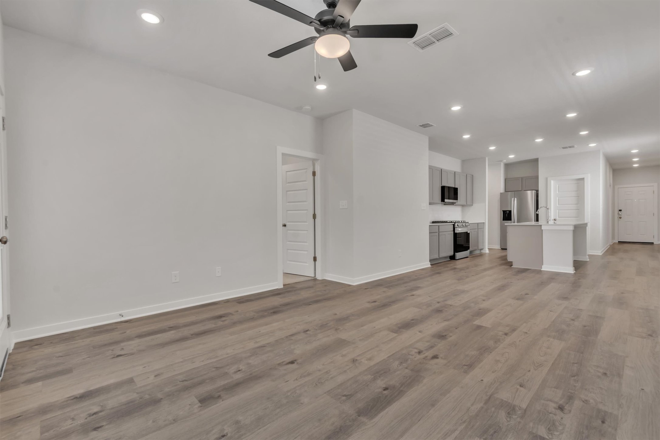 228 Bendecido Loop Elgin, TX 78621 - Photo 11 of 16 An open-concept living space with resilient wood-look flooring flows into a contemporary kitchen.