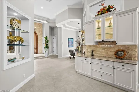 a kitchen with white cabinets and window