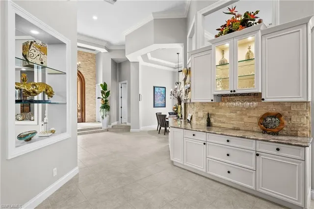 a kitchen with white cabinets and window
