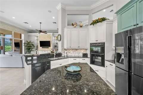 a kitchen with granite countertop a sink stove and refrigerator