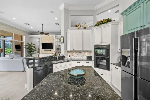 a kitchen with granite countertop a sink stove and refrigerator