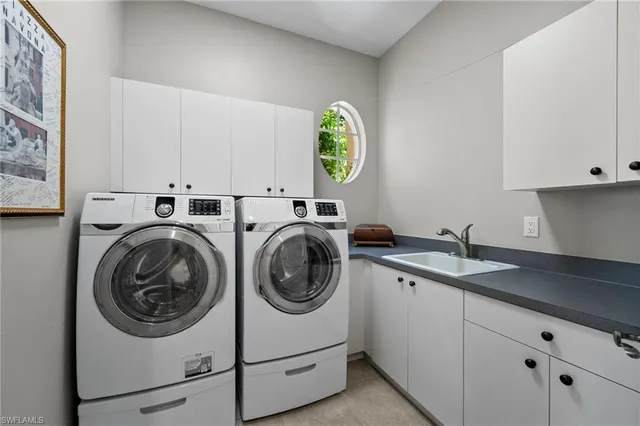 a utility room with sink dryer and washer