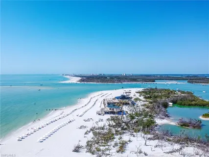 an aerial view of ocean and residential houses with outdoor space