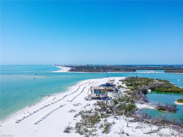 an aerial view of ocean and residential houses with outdoor space