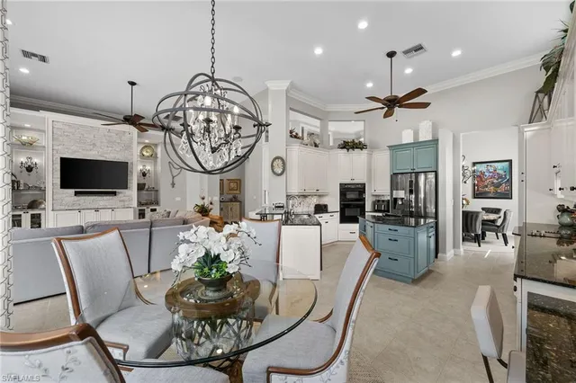 a living room with furniture a flat screen tv and kitchen view