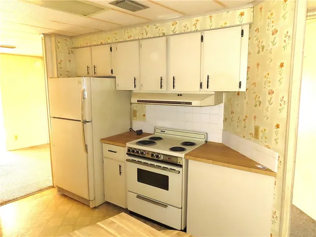 a kitchen with a stove a refrigerator and a sink