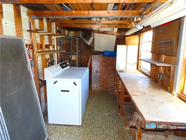 a view of a lake with lawn chairs under an umbrella