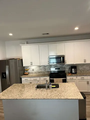a kitchen with stainless steel appliances granite countertop a sink stove and refrigerator