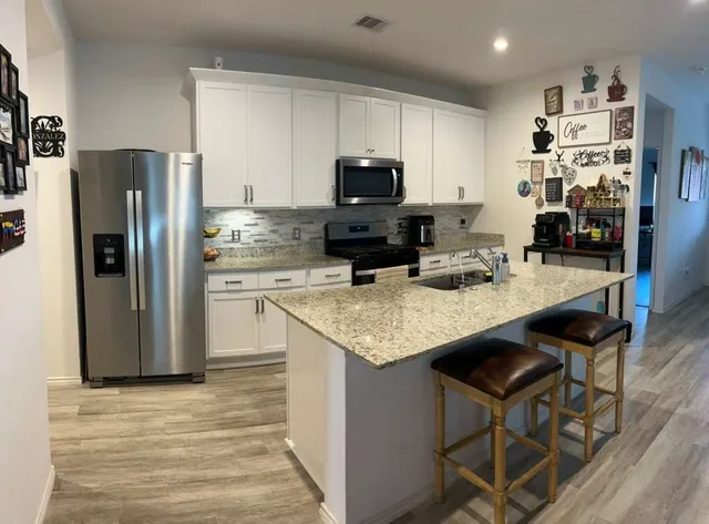 a kitchen with stainless steel appliances granite countertop a refrigerator stove top oven a sink and dishwasher