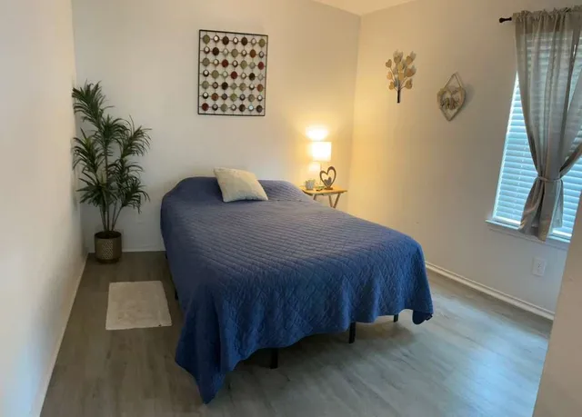 a bedroom with a bed and a potted plant