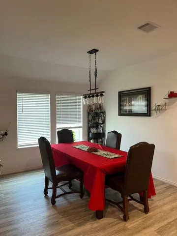 a dining room with furniture window and wooden floor