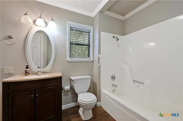 a bathroom with a toilet sink vanity tub and mirror