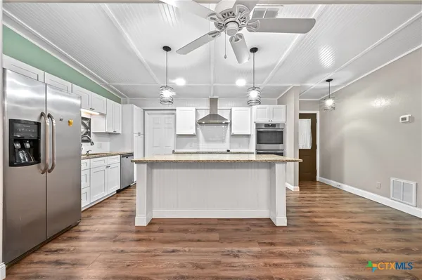 a large kitchen with stainless steel appliances kitchen island a large island in the center