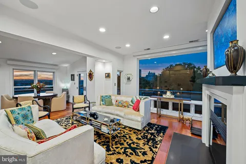 a living room with fireplace furniture and a potted plant