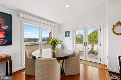 a view of a city from a balcony with table and chairs