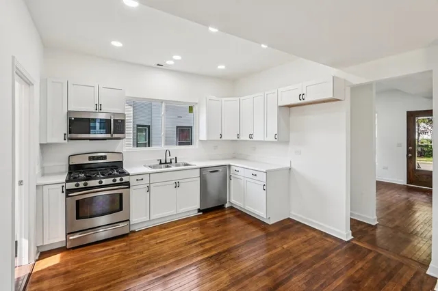 a kitchen with granite countertop a stove top oven and cabinets