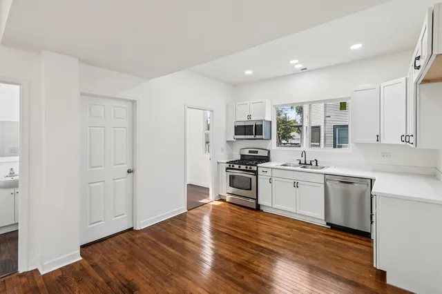 a kitchen with stainless steel appliances a refrigerator and a stove top oven