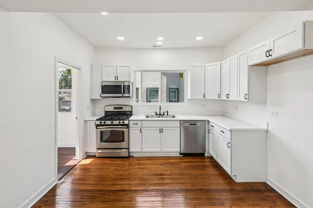 a kitchen with granite countertop a stove top oven and cabinets
