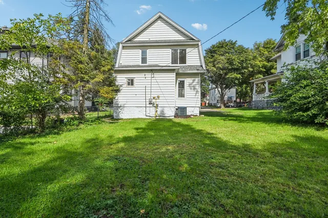 a front view of a house with a yard and trees