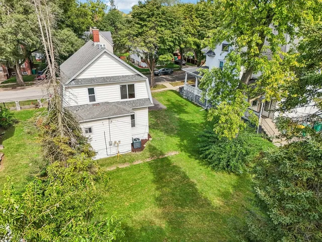 a front view of a house with a yard and trees