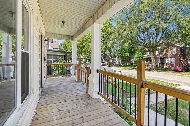 a view of a porch with wooden floor and wooden fence