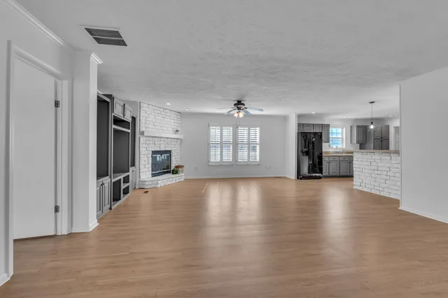 a view of a livingroom with wooden floor and a fireplace