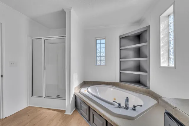 a spacious bathroom with a tub sink and a mirror