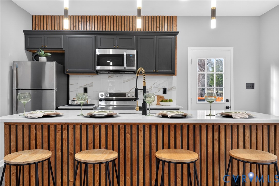 1952 Powell Road Richmond, VA 23224 - Photo 11 of 36 a kitchen with stainless steel appliances granite countertop a sink a stove a kitchen island with a dining table and chairs