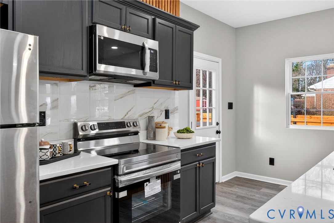 1952 Powell Road Richmond, VA 23224 - Photo 13 of 36 a kitchen with stainless steel appliances a stove microwave and refrigerator