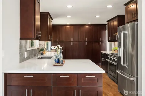 a kitchen with stainless steel appliances kitchen island granite countertop a sink window and cabinets