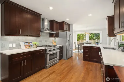 a kitchen with stainless steel appliances granite countertop wooden cabinets stove top oven and sink