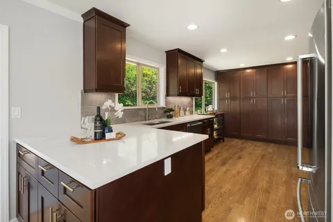 a kitchen with kitchen island a refrigerator and a sink