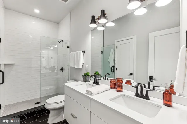 a bathroom with a sink a toilet and shower