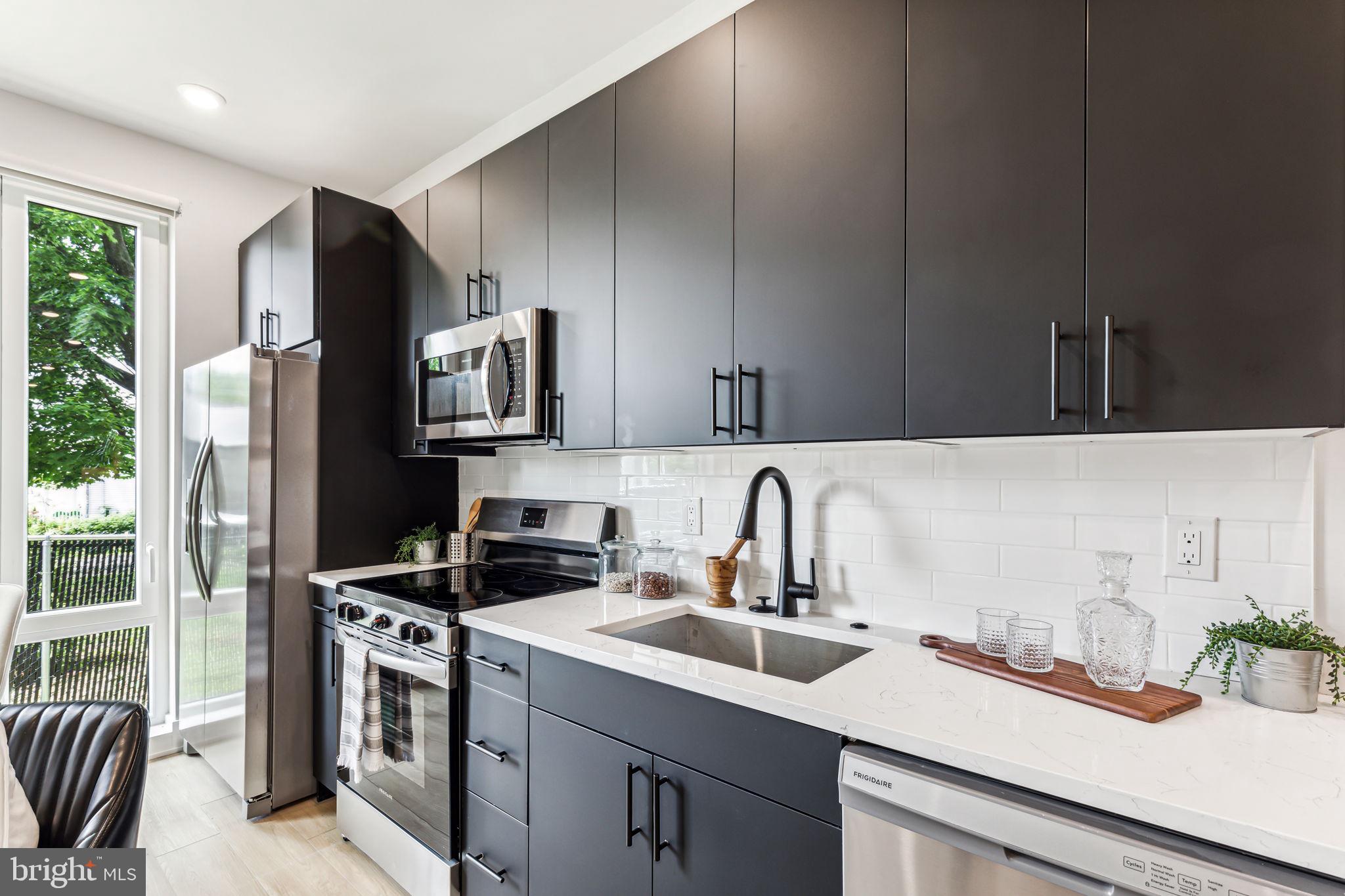 6910 Ridge Avenue, Unit 407 Philadelphia, PA 19128 - Photo 5 of 18 a kitchen with a sink stove and refrigerator