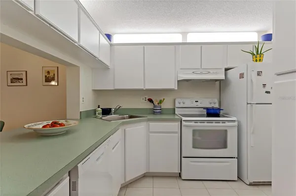 a kitchen with white cabinets and white appliances