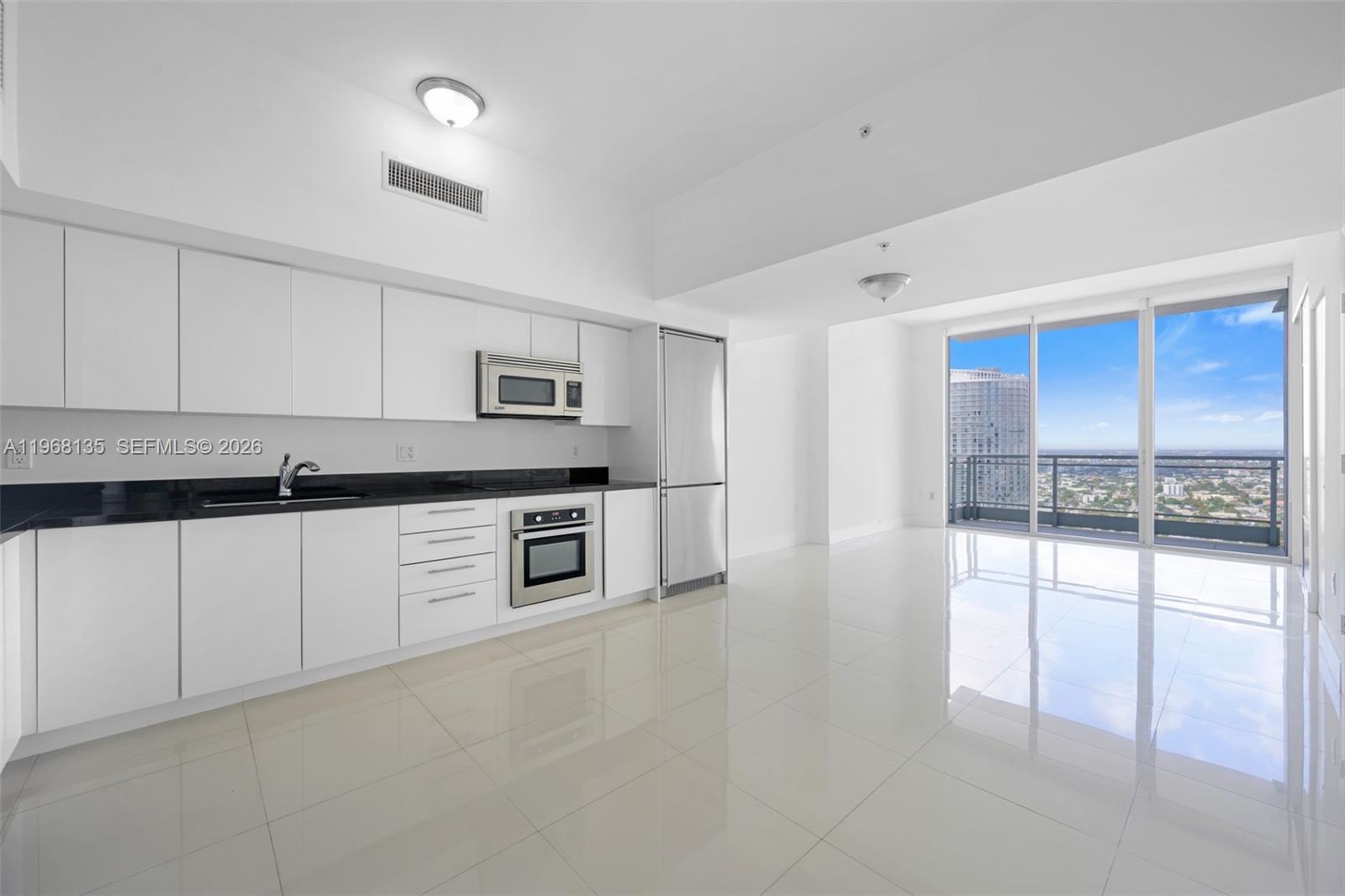 a kitchen with stainless steel appliances granite countertop a stove and white cabinets